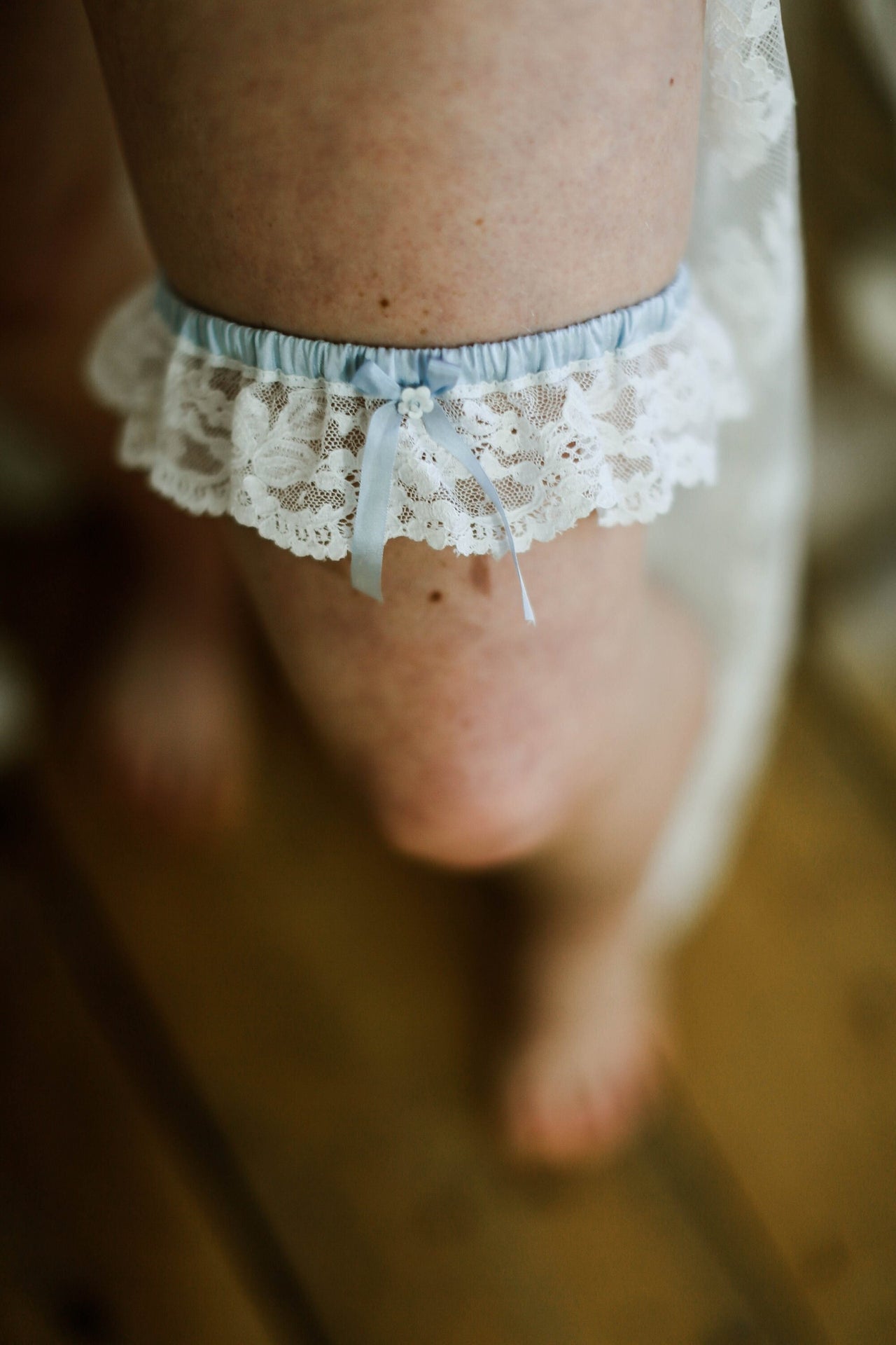 Lace wedding garter, with blue silk bow and tiny beaded flower.